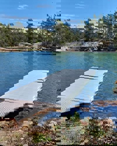 EasyFloat kajakbrygga med landgång på klart turkost vatten, redo för kajaker.